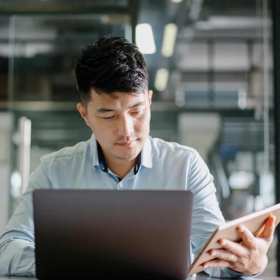 man working on laptop having tablet
