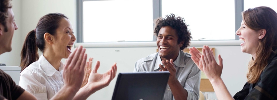 Four businesspeople in office applauding energy efficiency improvements